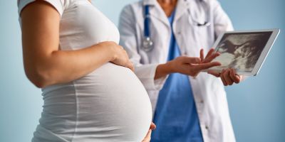 pregnant woman talking to doctor who is showing her an ultrasound picture and talking about opiod abuse