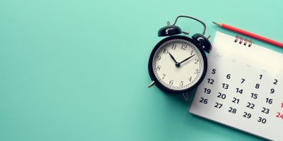 antique clock on calendar noting how long something takes