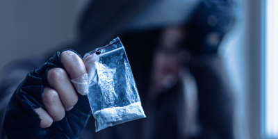 man holding up a bag of crystal meth