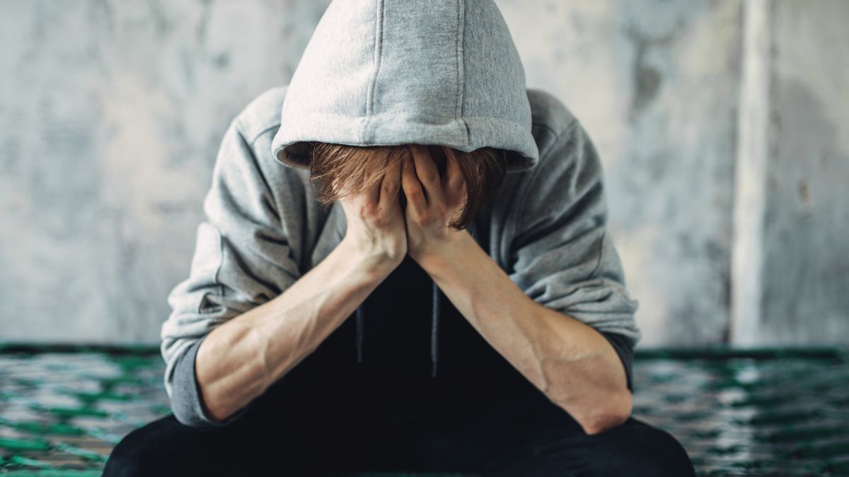 man sitting down with his head in his hands wondering how long does heroin withdrawal last?