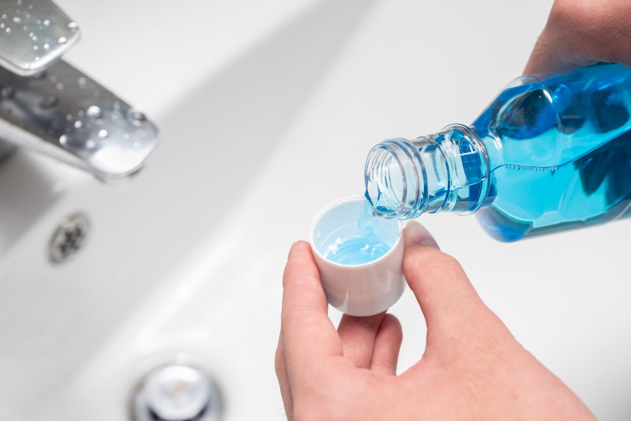 man pouring mouthwash into the cap wondering what happens if you drink mouthwash